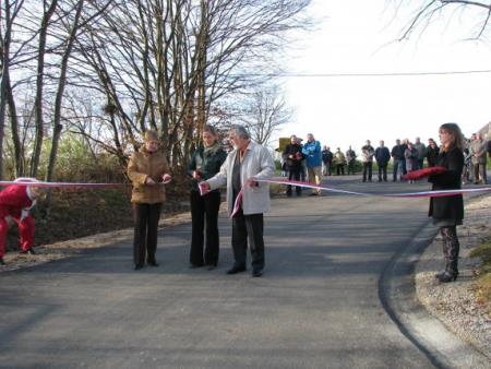 Trak ob odprtju obnovljene ceste za Podtabor so prerezali (z leve)- Anica Žlogar, predstavnica vasi Podtabor v svetu KS Šembije Jana Logar in župan Anton Šenkinc